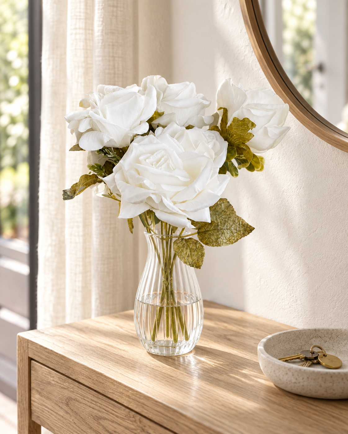 One white Small Full Bloom Rose Posy in a clear ribbed glass vase on an oak entryway console beside a round mirror; vase not included.