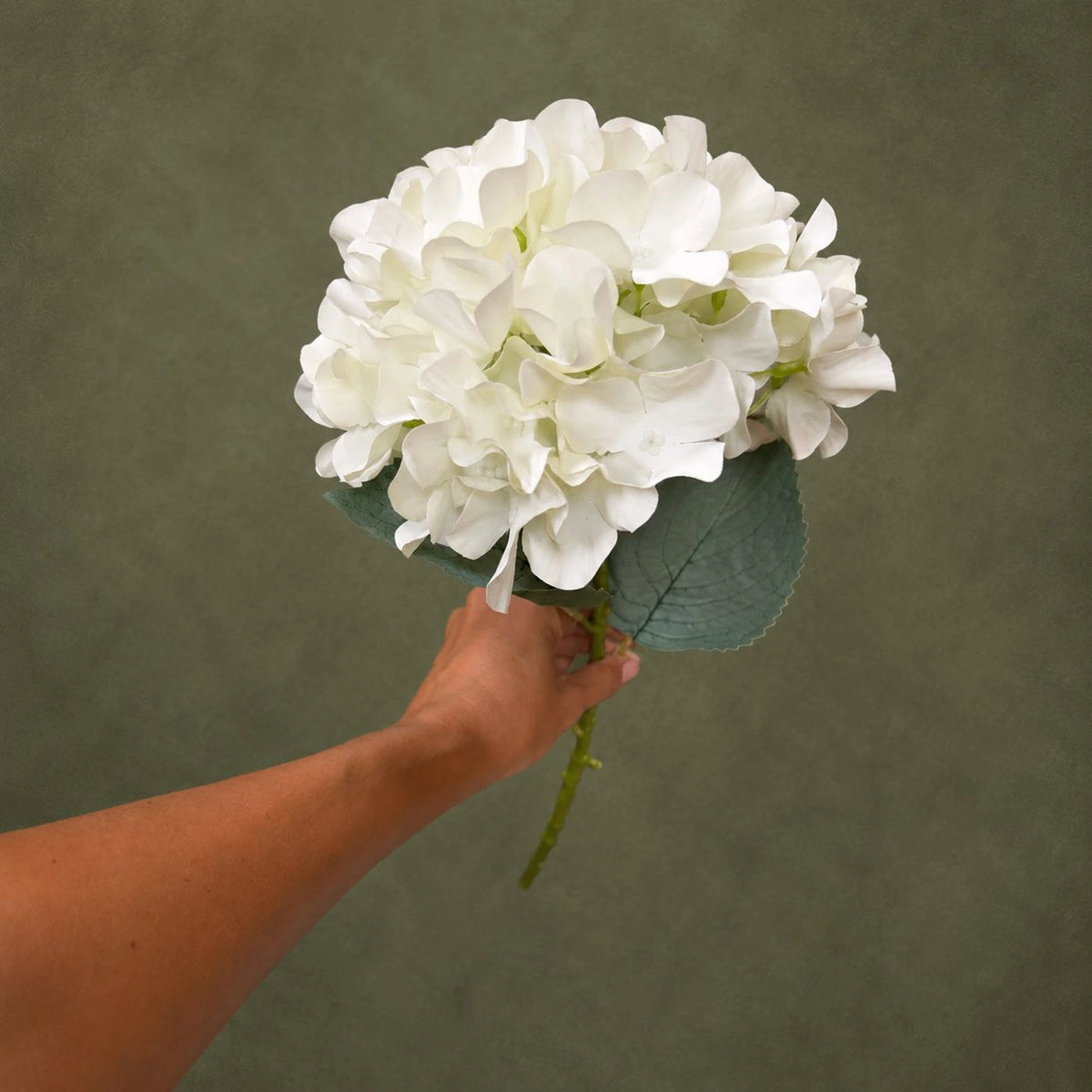 blush pink artificial hydrangea stem 80cm premium tall faux wedding bloom lifestyle scene: florist arranging stem