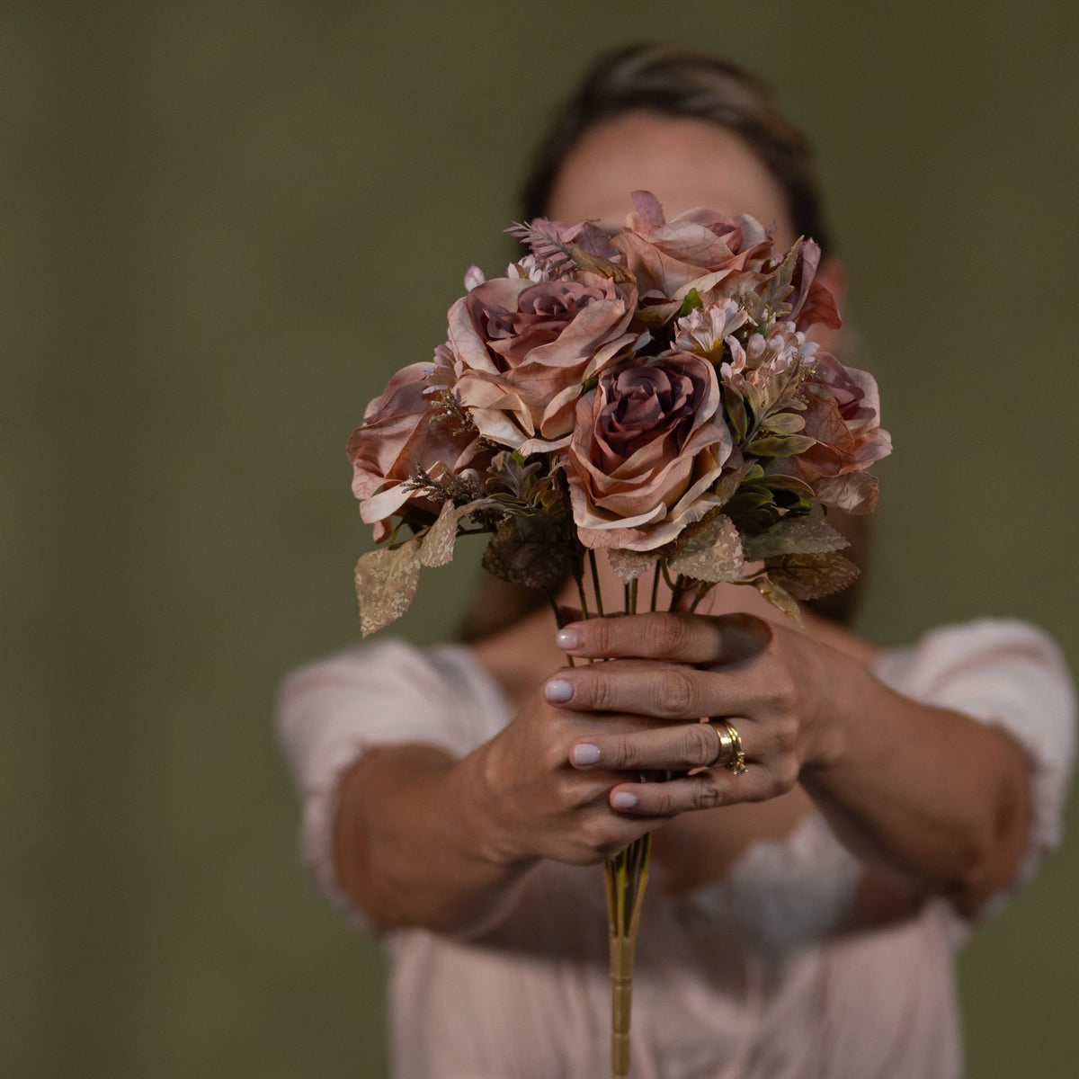 premium peach vintage rose floral bouquet luxury pre arranged artificial centerpiece lifestyle scene: person carrying or gifting bouquet