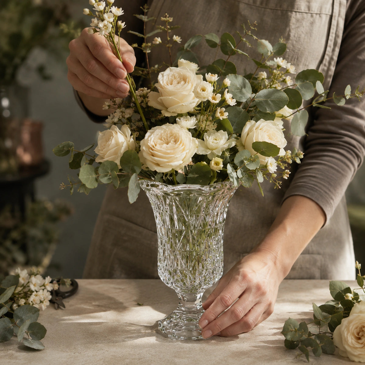 crystal cut glass pedestal vase premium footed luxury urn for floral displays lifestyle scene: florist arranging filled vessel