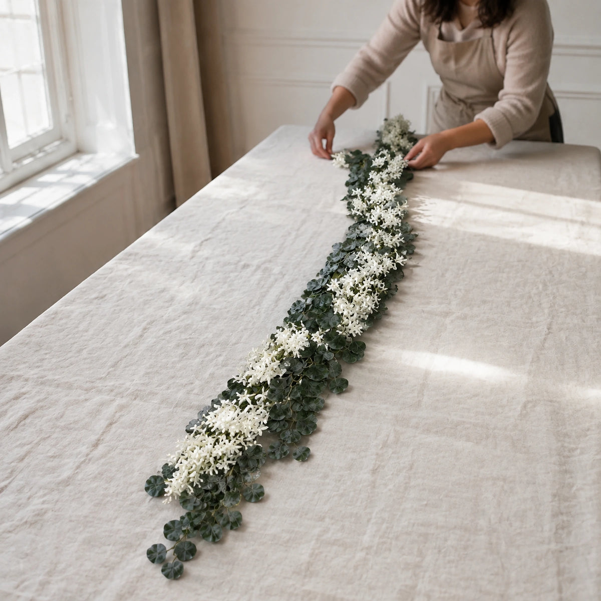artificial jasmine eucalyptus garland white lifestyle scene: florist installing garland