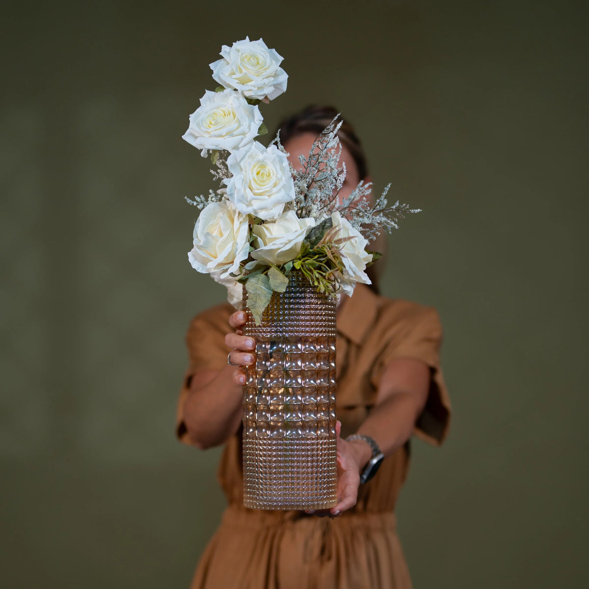 white rose artificial floral arrangement premium amber glass vase centerpiece lifestyle scene: host or florist placing arrangement